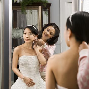 Royalty Free Photo of a Woman Helping a Bride With Her Hair