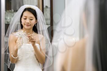 Royalty Free Photo of a Bride Looking at Her Bouquet in the Mirror