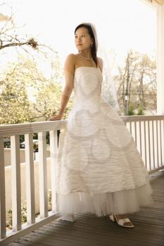 Royalty Free Photo of a Bride Leaning Against Railing