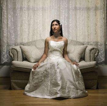 Royalty Free Photo of an Indian Bride Sitting on a Love Seat