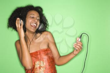 Royalty Free Photo of an African American Woman Listening to Music Through Headphones