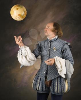Royalty Free Photo of a William Shakespeare in Period Clothing Tossing a Globe
