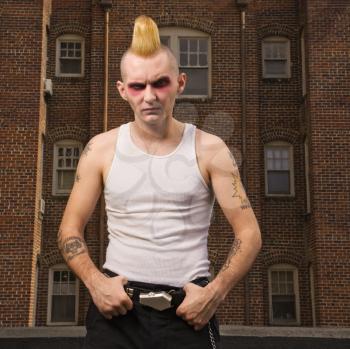 Royalty Free Photo of a Male Punk Outside With a Building in the Background