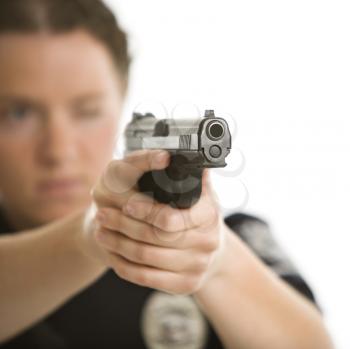 Royalty Free Photo of a Close-up of a Female Law Enforcement Officer Aiming Her Gun With One Eye Closed