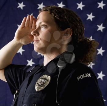 Royalty Free Photo of a Policewoman Saluting With an American Flag as a Backdrop