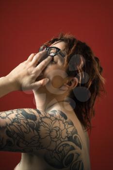 Royalty Free Photo of an Adult Woman With Tattoos Rubbing Her Eyes