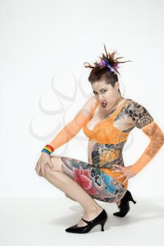 Royalty Free Photo of a Woman With Tattoos Squatting on a Floo