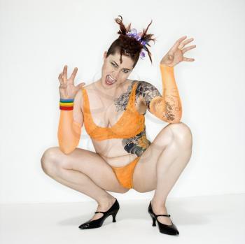 Royalty Free Photo of a Woman With Tattoos Squatting on the Floor
