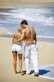 Royalty Free Photo of an Attractive Couple Walking on Maui, Hawaii Beach With Arms Around Each Other