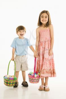 Royalty Free Photo of a Girl and Boy Standing Holding Easter Baskets