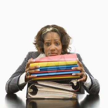 Royalty Free Photo of a Businesswoman Resting Her Head on a Large Stack of Books and Files