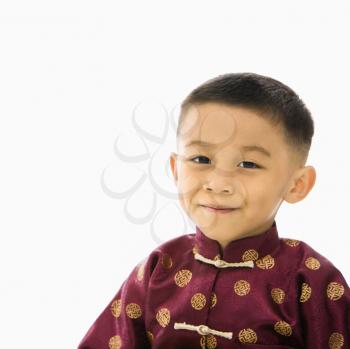 Royalty Free Photo of a Boy Standing Against a White Background in Traditional  Attire