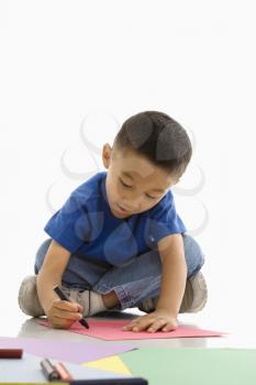 Royalty Free Photo of a Boy Colouring on Construction Paper
