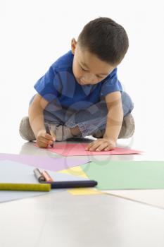 Royalty Free Photo of a Boy Colouring on Construction Paper