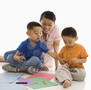Asian mother with boys coloring.