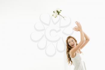 Royalty Free Photo of a Caucasian Bride Tossing a Bouquet Behind Her