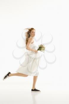 Royalty Free Photo of a Bride Running and Holding a Bouquet