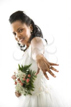 Portrait of a mid-adult African-American bride showing ring to viewer.