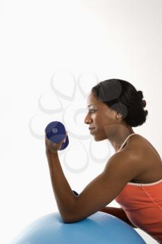 Royalty Free Photo of a Woman Leaning on an Exercise Ball Holding a Dumbbell