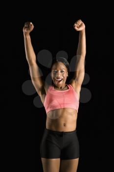 Royalty Free Photo of a Smiling Woman in a Sports Bra Stretching Arms Above Her Head