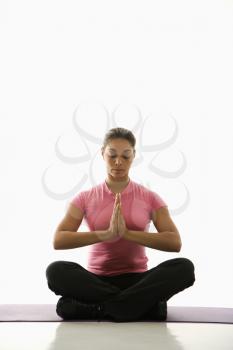 Royalty Free Photo of a Woman Sitting in Namaste Position on an Exercise Mat With Eyes Closed and Hands at Heart Center