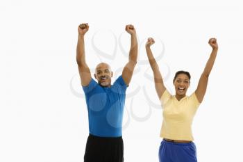 Royalty Free Photo of a Man and Woman Raising Their Arms and Smiling