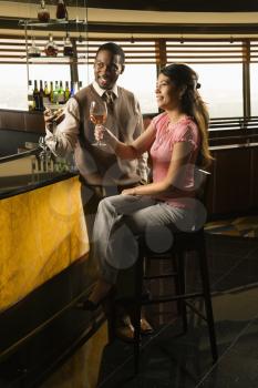 Royalty Free Photo of a Man Toasting a Woman at a Bar