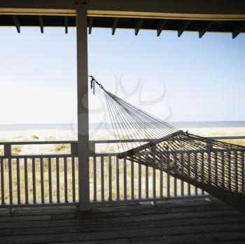 Royalty Free Photo of a View of the Beach From a Porch With Railing and Hammock at Bald Head Island, North Carolina