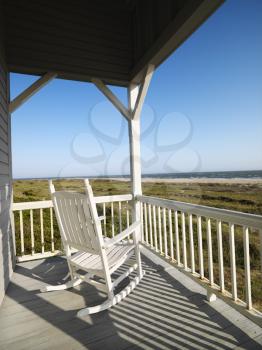 Royalty Free Photo of a Rocking Chair on a Porch Overlooking a Beach at Bald Head Island, North Carolina