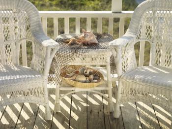 Royalty Free Photo of Two Wicker Chairs With a Table Between Them With Seashells