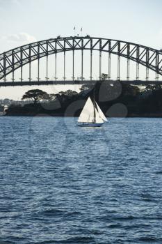 Royalty Free Photo of the Sydney Harbour Bridge and a Sailboat in Sydney, Australia