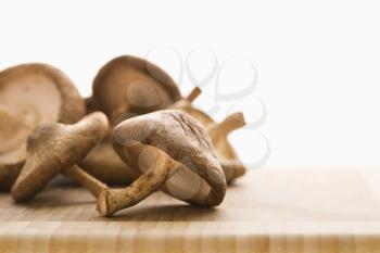 Royalty Free Photo of a Pile of Brown Mushrooms on a Cutting Board
