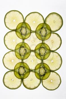 Lime and kiwi fruit slices arranged on white background.