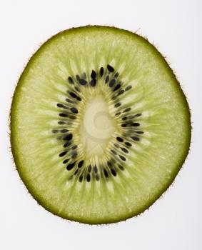 Close up of single kiwi fruit slice on white background.