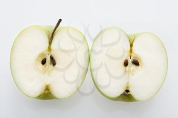 Still life of sliced green apples on white background.