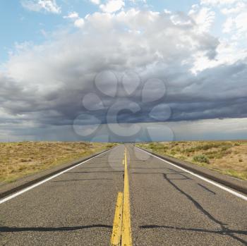 Royalty Free Photo of an Empty Two Lane Highway Leading to a Desert Horizon