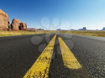 Royalty Free Photo of an Open Highway in a Scenic Desert Landscape With Distant Mountains and Butte Land Formations