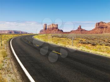 Royalty Free Photo of a Road in Scenic Desert Landscape With Mesa and Mountains