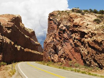 Royalty Free Photo of a Rural Road Dug Through a Large Rock Formation in Utah