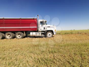 Royalty Free Photo of a Side View of a Semi Truck in an Agricultural Field