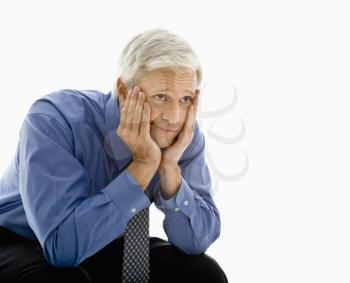 Royalty Free Photo of a Middle-Aged Man With Head Resting in His Hands Looking Bored