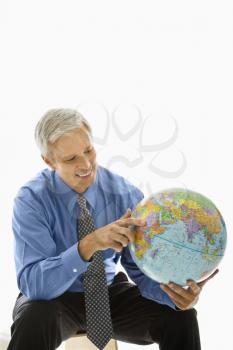 Royalty Free Photo of a Businessman Holding a Globe and Pointing