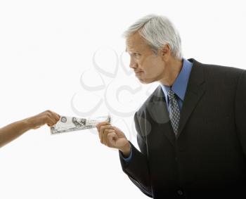 Royalty Free Photo of a Middle-Aged Businessman Pulling a Hundred Dollar Bill From a Woman