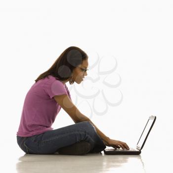 Royalty Free Photo of a Woman Sitting on Floor Using Her Laptop