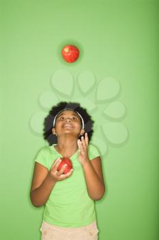 Royalty Free Photo of an African American Girl Juggling Apples