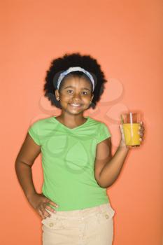 Royalty Free Photo of a Girl With Hand on Hip Holding a Glass of Orange Juice