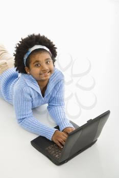 Royalty Free Photo of a Girl Lying on the Floor Using a Laptop