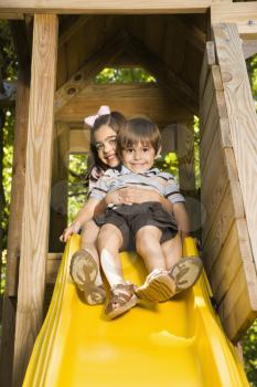 Royalty Free Photo of a Girl Hugging a Boy on Top of a Slide