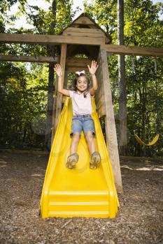 Royalty Free Photo of a Girl Going Down a Slide