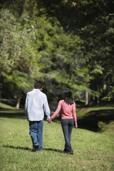 Royalty Free Photo of a Couple Holding Hands Walking and Talking in a Park